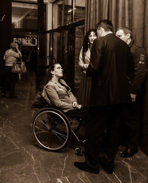 Artur, reżyser rozmawia z widzami po premierze. Dwoje osób w średnim wieku i młoda kobieta na wózku.